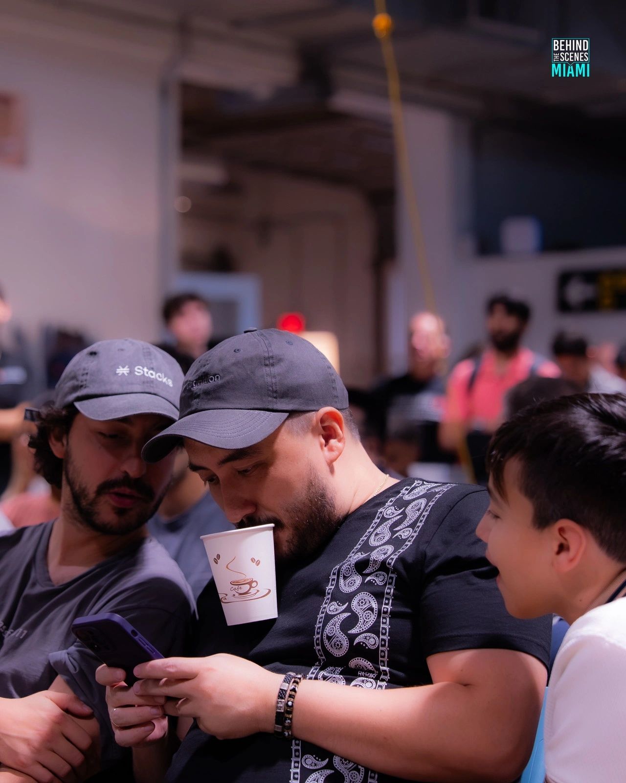 Café en una mano y el plan en la otra: los hackers comparan notas a mitad de construcción.