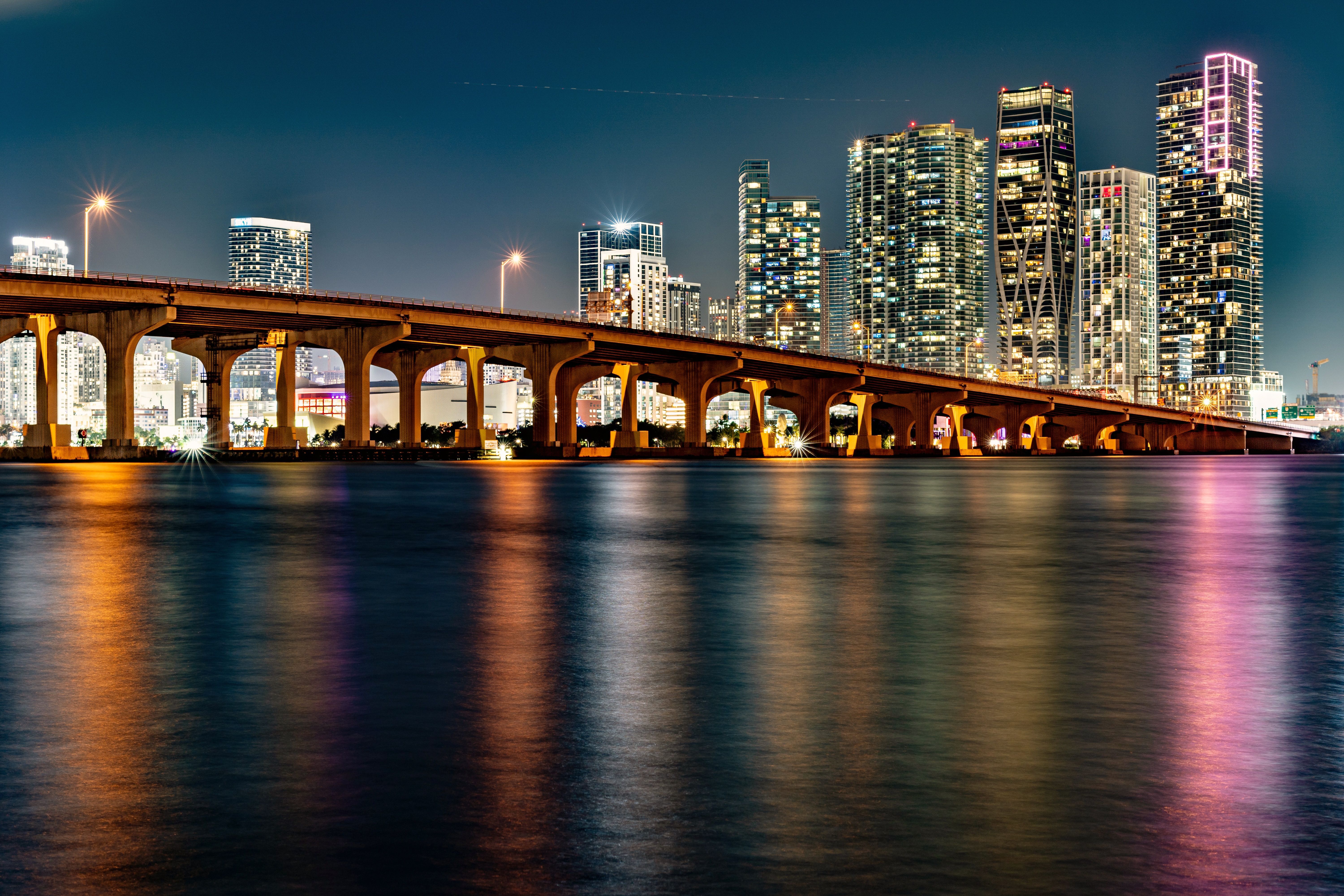 El skyline de Miami de noche sobre la bahía Biscayne, con el puente iluminado en primer plano